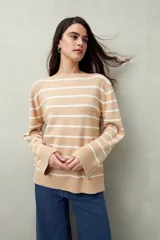 Sweater de punto color beige con rayas horizontales blancas, cuello bote y corte holgado.