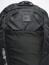 Mochila de trekking color negro, confeccionada en nylon ripstop. Cuenta con compartimento principal amplio, bolsillo frontal abierto, compartimento superior con cierre y pasadores exteriores para accesorios. Incluye tiras ajustables con broche frontal y cubre lluvia integrado.