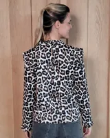 Polera de manga larga color blanco, confeccionada en algodón, con cuello alto tipo tortuga y detalles de volados en el cuello y en los puños.
