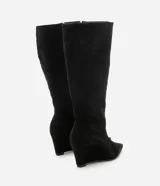 Bota de caña media con taco tipo anabela, confeccionada en gamuza sintética color negro. Presenta puntera fina, cierre lateral y diseño elegante con estructura ajustada.