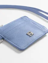 Tarjetero amarillo de cuero vegano con textura granulada, cierre superior con cremallera, tres ranuras para tarjetas y correa de muñeca.