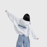 Hoodie blanco de corte oversize con capucha y estampa gráfica en la espalda con tipografía estilo industrial y código de barras.