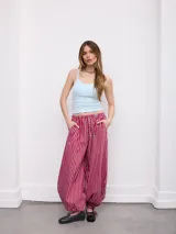 Pantalón palazzo tiro alto con estampado a rayas horizontales rojas, celestes y blancas. Cuenta con cintura elástica y puños ajustables en los tobillos.