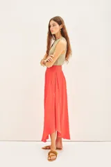 Falda midi de corte fluido con cintura elástica fruncida, confeccionada en tejido satinado de color coral.