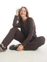 Conjunto de dos piezas compuesto por un buzo de cuello redondo con mangas raglán y un pantalón de pierna ancha con cintura elástica. Confeccionado en tejido de tacto suave con puños acanalados.