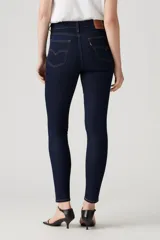 Jeans de tiro alto color azul oscuro, corte ajustado en cadera y muslos, con pierna skinny y cierre de cremallera.