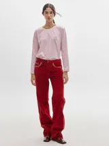 Pantalón de tiro medio confeccionado en pana color rojo, con corte holgado y detalle de línea lateral en contraste.