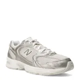 Championes urbanos New Balance modelo 530, con diseño retro en tonos beige y detalles metalizados en dorado. Confeccionados en malla transpirable y capas superpuestas de material sintético, cuentan con tecnología de amortiguación ABZORB en la entresuela.