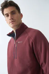 Buzo polar de algodón azul marino con cuello elevado, logo estampado, bolsillo frontal con cierre y medio cierre frontal.