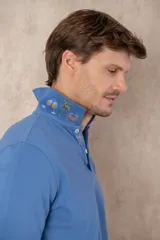 Chomba azul de piqué de algodón con cuello polo, tapeta de dos botones con diseño estampado en el interior y mangas cortas. Corte clásico.