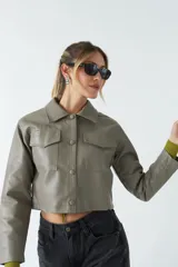Sobrecamisa de eco cuero con corte cropped, silueta recta y bolsillos frontales con tapa. Presenta cierre frontal con botones y acabado soft.
