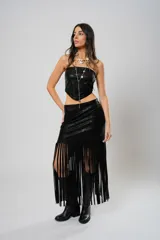 Falda midi negra de cuero sintético con flecos largos y abertura lateral.