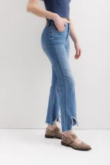 Pantalón jean de corte acampanado, tiro alto, color celeste y terminación desflecada.