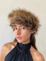 Gorro tipo banda de piel sintética en tonos marrones y beige, con textura voluminosa y diseño envolvente.