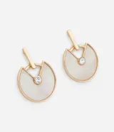 Par de caravanas con diseño circular abierto, confeccionados en metal con baño dorado. Presentan una pieza de nácar en forma de semicírculo y un detalle de strass en el centro.