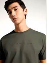 Camiseta blanca de algodón con cuello redondo y mangas cortas. Estampa rectangular con borde negro que contiene la frase "NATURAL ATMOSPHERE" en letras mayúsculas y una imagen de montañas y mar.