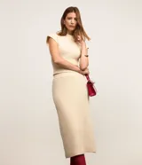 Pollera evasé midi de punto con cintura alta y elástico. Presenta un diseño con traspase delantero.