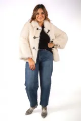 Tapado de piel sintética en color beige, con cuello solapa y cierre frontal mediante tres botones tipo toggle con detalles en cuero negro.