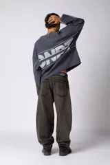 Buzo oversize de corte boxy, confeccionado en algodón rústico de alto gramaje en color beige. Presenta cuello redondo con borde crudo, mangas largas y una estampa frontal con el texto VCP delimitado por líneas horizontales blancas.