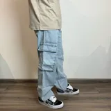 Pantalón jean cargo gris con efecto lavado, corte recto y bolsillos laterales.