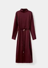 Vestido midi de tejido satinado en color bordó, de corte recto con manga larga, cuello alto y abertura en el bajo delantero. Incluye un cinturón ajustable delgado con detalle metálico dorado.