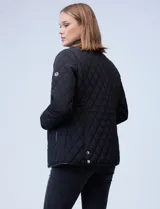 Campera capitoneada azul marino con cuello y ribetes en cuero marrón, marca Michael Kors. Abertura central con botones metálicos dorados, bolsillos verticales delanteros y logo metálico en el brazo.