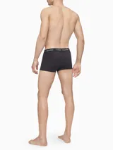 Pack de tres boxers tipo trunk Calvin Klein, confeccionados en algodón elástico. Presentan un diseño liso en color negro con cintura elástica distintiva de la marca con el logo estampado en contraste.