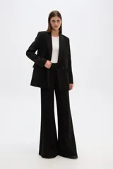 Blazer de corte holgado en color blanco, con cuello solapa, cierre frontal con botones y bolsillos laterales con solapa.