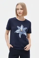 Remera de manga corta color azul marino con cuello redondo y estampado frontal de una flor en tonos celestes y blancos.