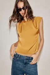Musculosa de tejido satinado con cuello redondo y detalle de nudo en uno de los hombros.