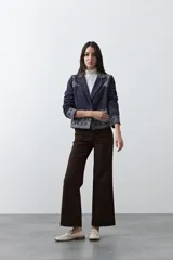 Blazer de gamuza color terracota con bordados decorativos en color crudo en solapas, puños y ruedo. Presenta corte recto, solapas clásicas y cierre frontal con un botón forrado.