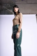 Pantalón de cuero negro con pretina con apliques de tachas y tajo delantero.