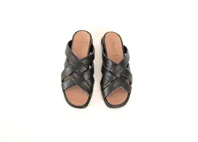 Sandalias planas Denu color negro, confeccionadas a mano en cuero con textura suave y diseño de tiras cruzadas en el empeine. Cuentan con plantilla anatómica y suela flexible de poliuretano.