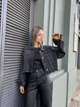 Campera de jean negra con tachas plateadas en cuello, hombros y bolsillos.