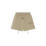 Short de felpa estilo deportivo color beige con cintura elástica con cordón ajustable largo, bolsillos laterales y el logo "Essentials" impreso en la pierna izquierda.