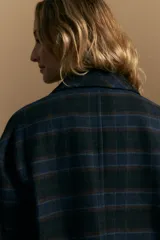 Tapado corto de lana con diseño a cuadros en tonos azul y negro, cuello camisero y cierre frontal con botones.