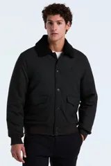 Campera tipo bomber color gris oscuro, con cuello de sherpa negro, cierre frontal con botones y bolsillos laterales con solapa. Presenta puños y ruedo de tejido elástico.