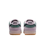Championes Nike SB Dunk Low Pro confeccionados en gamuza, con base en color verde y superposiciones en tono lila. Cuenta con el característico swoosh en color azul oscuro, entresuela rosada y suela de goma marrón.