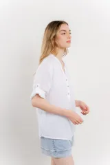 Camisa color topo confeccionada en lino, de corte holgado, con escote en V abotonado, bolsillo frontal y mangas 3/4 arremangables.