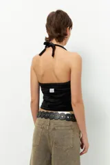 Top negro de terciopelo con escote halter, sin mangas y espalda descubierta.