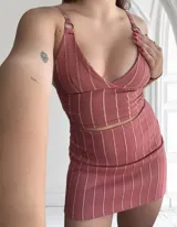 Conjunto de top y pollera color rosa con rayas verticales blancas. El top es de breteles finos y escote en V. La pollera es corta y ajustada.