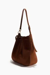 Cartera bandolera de gamuza color marrón, con diseño de pliegues cosidos y cordón ajustable en la parte superior. Cuenta con correa de hombro ajustable y herrajes metálicos.