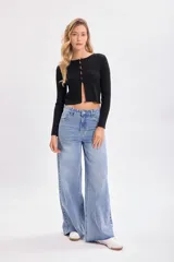 Cárdigan negro de punto canalé con botones frontales y mangas largas.