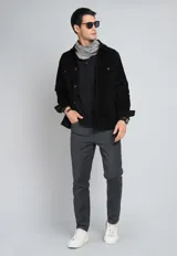 Sobrecamisa negra de pana con cuello clásico, cierre frontal con botones, dos bolsillos de parche con solapa en el pecho y puños abotonados.