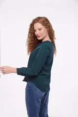Blusa verde con cuello en V y mangas largas.