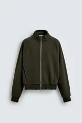 Sudadera de hombre color verde oscuro con efecto lavado, corte relajado y cuello alto. Presenta cierre frontal metálico, bolsillos ocultos en costura y puños y bajo en rib.