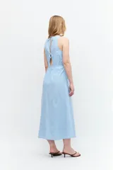 Maxi vestido celeste con rayas verticales blancas, cuello halter y lazo ajustable en la cintura.