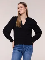 Blusa negra de rayón con textura smock en la pechera, escote en V con cuello mao fruncido, mangas largas fluidas con puños anchos y detalle de volados en el ruedo.