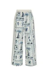 Pantalon ancho de tiro alto de Le Lis Blanc con estampado de palmeras y motivos tropicales en azul y blanco.