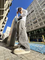Pantalón de jean con corte baggy y diseño balloon, de color gris lavado con efecto desgastado. Presenta costuras laterales curvadas y una silueta amplia y holgada.